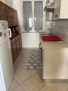 a kitchen with a sink and a refrigerator at Domo Mea in Cardedu