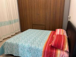 a bedroom with a bed and a wooden cabinet at Domo Mea in Cardedu