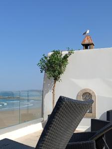 a tree on the side of a white building with a window at Riad d'exception vue mer au coeur de la médina Essaouira - Mandji Dream in Essaouira