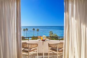 a dining room with a table and a view of the ocean at Hôtel Barrière Le Majestic Cannes in Cannes