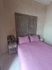 a bedroom with a large bed with purple sheets at Riad d'exception vue mer au coeur de la médina Essaouira - Mandji Dream in Essaouira