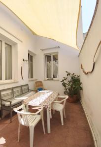 eine Terrasse mit einem Tisch, Stühlen und einer Bank in der Unterkunft Mamma Assuntina in Lecce