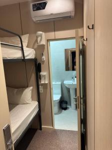 タシュケントにあるCity Centre B&Bの二段ベッド1組、バスルームが備わる小さな客室です。