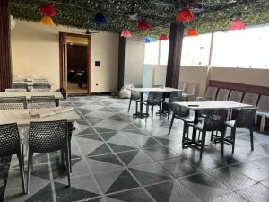 a dining room with tables and chairs in a room at Rudram Inn in Varanasi