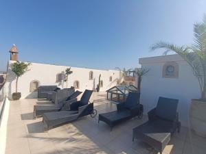 a row of lounge chairs on a patio at Riad d'exception vue mer au coeur de la médina Essaouira - Mandji Dream in Essaouira