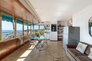 una cucina e un soggiorno con un tavolo e un frigorifero di Riviera Mare a Varazze