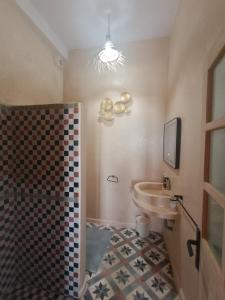 a bathroom with a sink and a tv on the wall at Riad d'exception vue mer au coeur de la médina Essaouira - Mandji Dream in Essaouira +24 photos