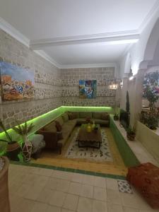 a living room with a green couch and a table at Riad d'exception vue mer au coeur de la médina Essaouira - Mandji Dream in Essaouira