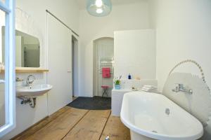 um banheiro branco com banheira e pia em Wohnzimmer em Krems an der Donau