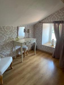 a bedroom with a dressing table and a mirror at Le Grand Charde in LʼIsle-Jourdain