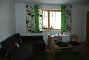 sala de estar con sofá, mesa y ventana en Ferienwohnung Kendler en Hüttschlag