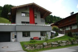 ein Haus mit einem roten Streifen auf der Seite in der Unterkunft Ferienwohnung Kendler in Hüttschlag