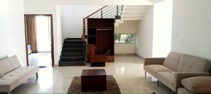 a living room with two couches and a staircase at PUSHPAM RANCHES And RESORT in Mattigiri