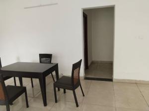 a dining room with a black table and chairs at PUSHPAM RANCHES And RESORT in Mattigiri