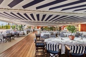 a dining room with tables and chairs and a striped ceiling at Hôtel Barrière Le Majestic Cannes in Cannes +37 photos