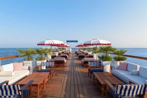 a dock with chairs and umbrellas on the beach at Hôtel Barrière Le Majestic Cannes in Cannes