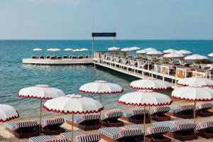 a pier with chairs and umbrellas on the beach at Hôtel Barrière Le Majestic Cannes in Cannes