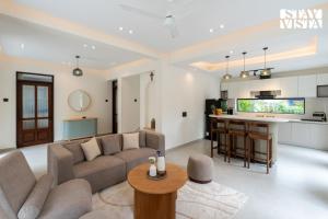 Una sala de estar con un sofá y una cocina. en StayVista at Roźe Home with Open Terrace, Pool & Pet Friendly, en Calangute