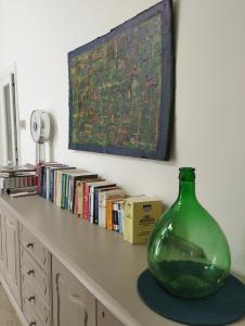 eine grüne Glasvase auf einem Tisch mit Büchern in der Unterkunft Mamma Assuntina in Lecce