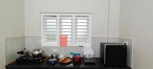 WayanadRhythm Residency Wayanad的带炉灶的厨房台和窗户