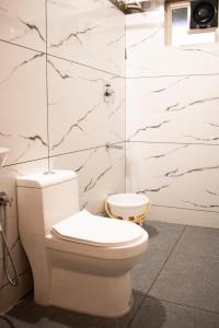 WayanadRhythm Residency Wayanad的浴室设有白色卫生间和大理石墙壁。