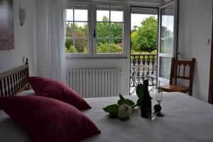 a bedroom with a bed with red pillows and a window at Hostal Pereiriña in Cee