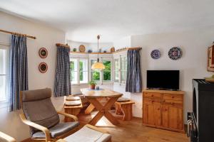 a living room with a table and a tv at Ferienhaus Zaunkönig in Mittenwald