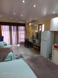 a room with two beds and a kitchen with a table at Sweet Dream Overnight in Postmasburg