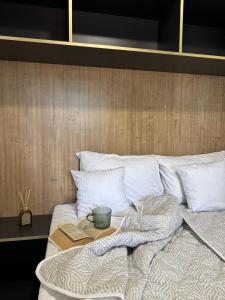 a bed with a book and a bowl on it at StayAdriatic Mobile Homes Olive in Sveti Filip i Jakov +41 photos