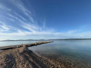 a beach with a pier in the water at StayAdriatic Mobile Homes Olive in Sveti Filip i Jakov