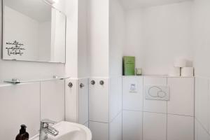 a white bathroom with a sink and a mirror at Ferienhaus Zaunkönig in Mittenwald +25 photos