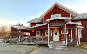 ein rotes Haus mit einem Schild an der Vorderseite in der Unterkunft Rutsbrogården in Rutån