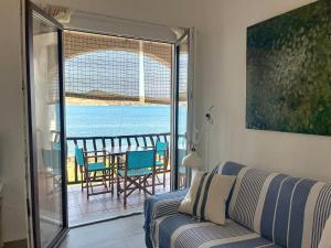 a living room with a couch and a view of the ocean at Roca Fornells, Un rinconcito en el mar P107 in Fornells