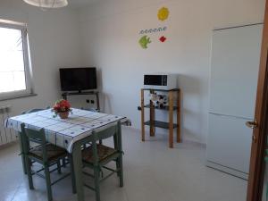 a kitchen with a table and a refrigerator at Appartamento La Collinetta in Gonnesa