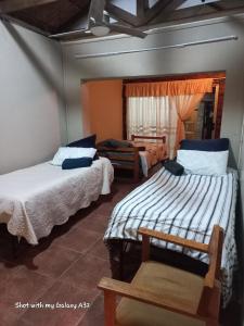 a room with two beds and a chair in it at Sweet Dream Overnight 2 in Postmasburg