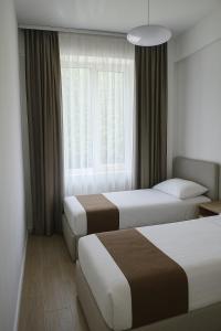 a hotel room with two beds and a window at Evergreen Stay Dilijan in Dilijan