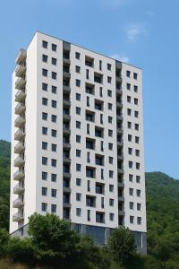 a tall white building with trees in front of it at Evergreen Stay Dilijan in Dilijan
