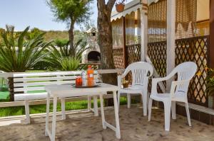 a white table and chairs on a porch with a tree at Kamarina Land in Santa Croce Camerina