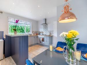 a kitchen with a table with a vase of flowers at Leehaven in Torquay