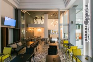 a restaurant with wooden tables and yellow chairs at Athens Cypria Hotel in Athens