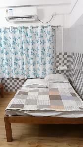 a bed in a room with a curtain and a window at Bridhi Guest House in Siliguri +14 photos