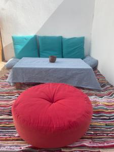 a red ottoman sitting in front of a table at Doody Cozy chalet in Dahab