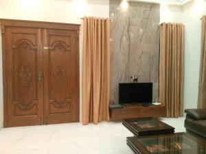 a living room with a wooden door and a television at Luxurious 2BR House in Dargai