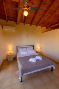 a bedroom with a large bed with two lamps at Amoni Holiday Homes in Kardamyli