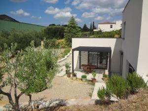 a house with a patio with a table and plants at studio des olivières in Montpeyroux