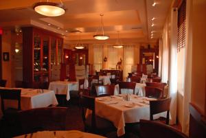 un restaurant avec des tables, des chaises et des nappes blanches dans l'établissement Hôtel Mingan, à Sept-Îles