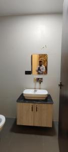 a bathroom with a sink and a person taking a picture at Hotel La Serene in Agra