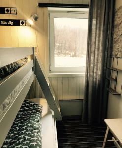 a small room with a bunk bed and a window at Kittelfjäll Vandrarhem in Kittelfjäll
