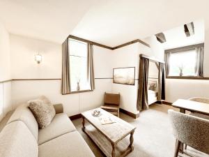 a living room with a couch and a table at Hotel the Farmhouse No 50 - kostenfreies Parken! - Cafe & Eventrooms in Osnabrück