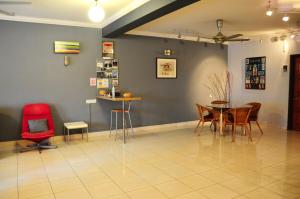 a dining room with a red chair and a table at GRAYHAUS 32 Spacious 3 Storey 5BR - Bandar Utama, near 1 Utama - Stay Only NO EVENTS in Petaling Jaya